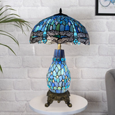16-inch blue & black Tiffany style cluster table lamp with stained glass design on a white brick wall background