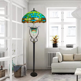 A Tiffany style 18-Inch stained glass floor lamp with a green color scheme, featuring a handcrafted shade and a metal base, placed in a living room setting.