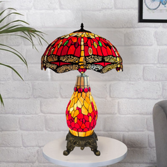 Decorative 6-inch red and yellow cluster table lamp with stained glass design on a white brick wall background