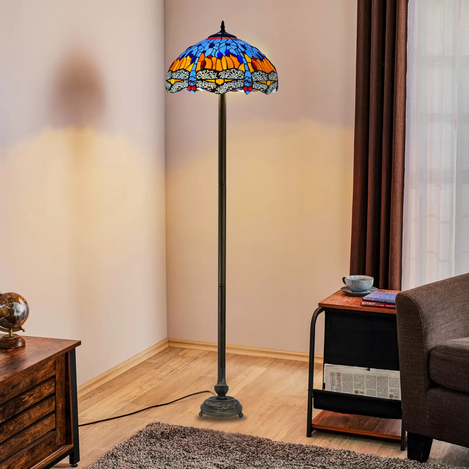 A 16 inch blue and orange dragonfly tiffany floor lamp placed in a living room beside a table and sofa
