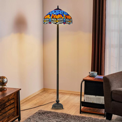 A 16 inch blue and orange dragonfly tiffany floor lamp placed in a living room beside a table and sofa