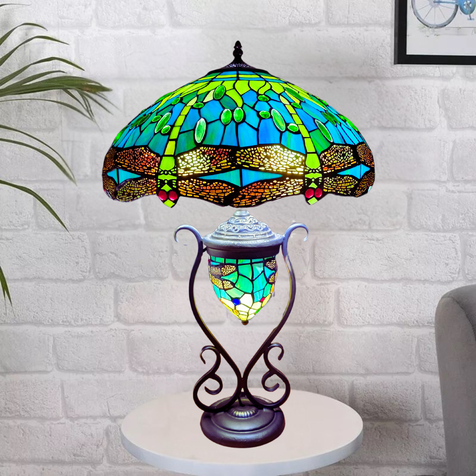 A green antique handmade tiffany style 18 inch cluster table lamp placed on a table with bricked wall background