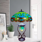 A beautiful green and blue tiffany style handmade stained glass 18 inch cluster table lamp with metal base placed on a desk 