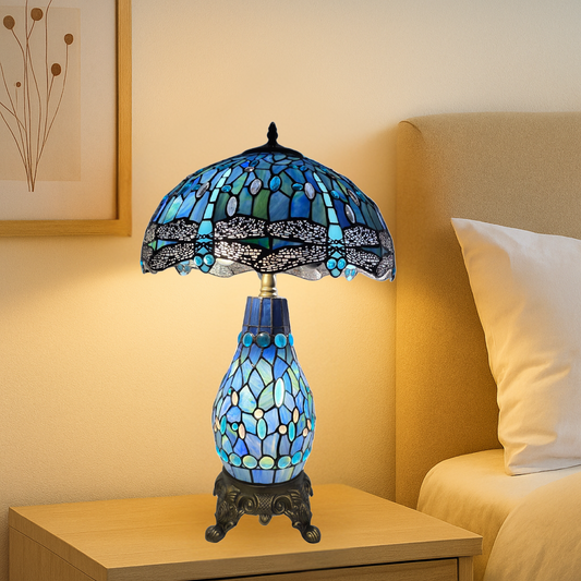 16-Inch blue and black tiffany style cluster table lamp with stained glass design on a nightstand next to a bed.